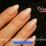 Dłoń z idealnym manicure hybrydowym. Pędzelek lakieru i pytanie "Jak wybrać najlepszą bazę pod hybrydę?".