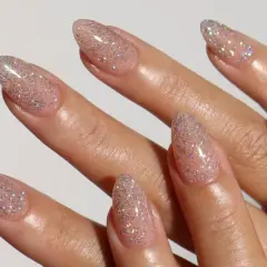Modne delikatne paznokcie w odcieniu nude z subtelnym brokatem. Idealne na każdą okazję, dodają blasku i elegancji.