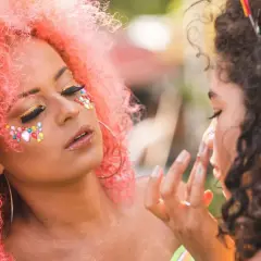 Kolorowe ozdoby i złote cienie na twarzy, idealny makijaż na festiwal.