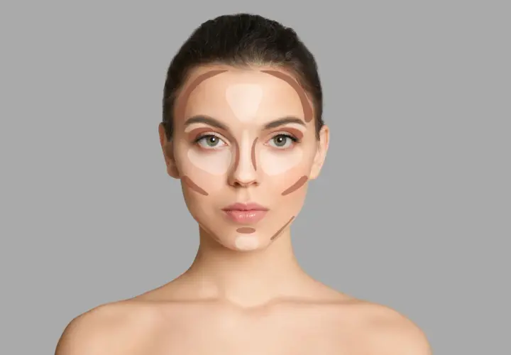 Modelka pokazuje, gdzie nałożyć bronzer i rozświetlacz, by wymodelować twarz. Linie zaznaczają kości policzkowe, czoło i nos.