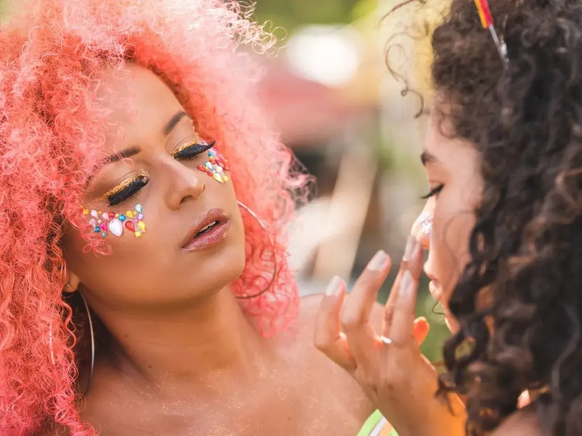 Kolorowe ozdoby i złote cienie na twarzy, idealny makijaż na festiwal.